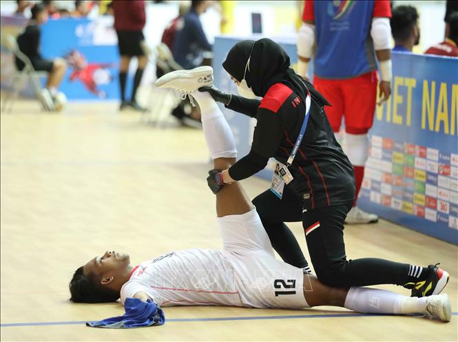 Chăm sóc y tế cho cầu thủ Ardiansyah (12) của Indonesia. Ảnh: Thanh Tùng - TTXVN