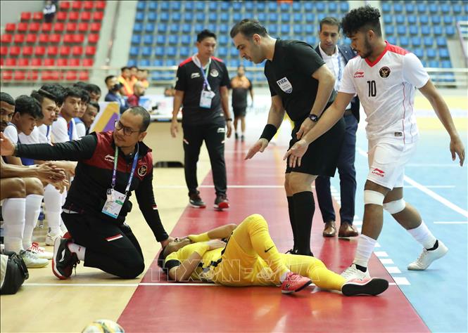 Pha bóng va chạm với Holypaul Septinus N Soumilena (10) khiến Mohd Khairul Effendy Bin Mohd Bahrin (7) của Malaysia bị đau. Ảnh: Thanh Tùng - TTXVN