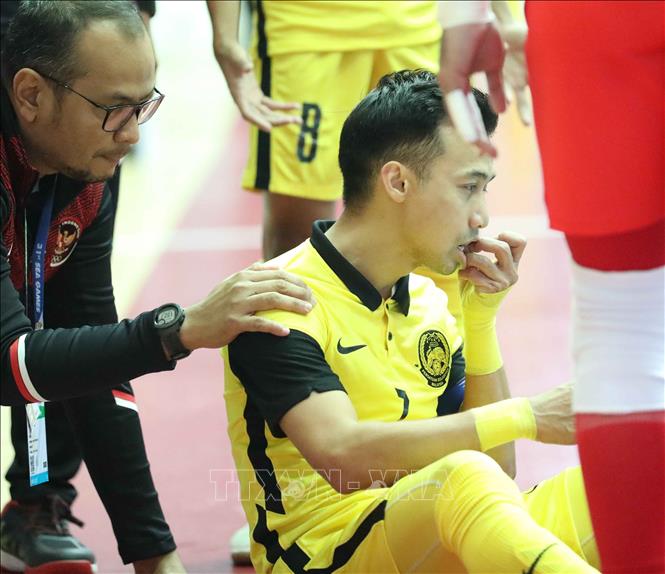 Pha bóng va chạm với Holypaul Septinus N Soumilena (10) khiến Mohd Khairul Effendy Bin Mohd Bahrin (7) của Malaysia bị đau. Ảnh: Thanh Tùng - TTXVN