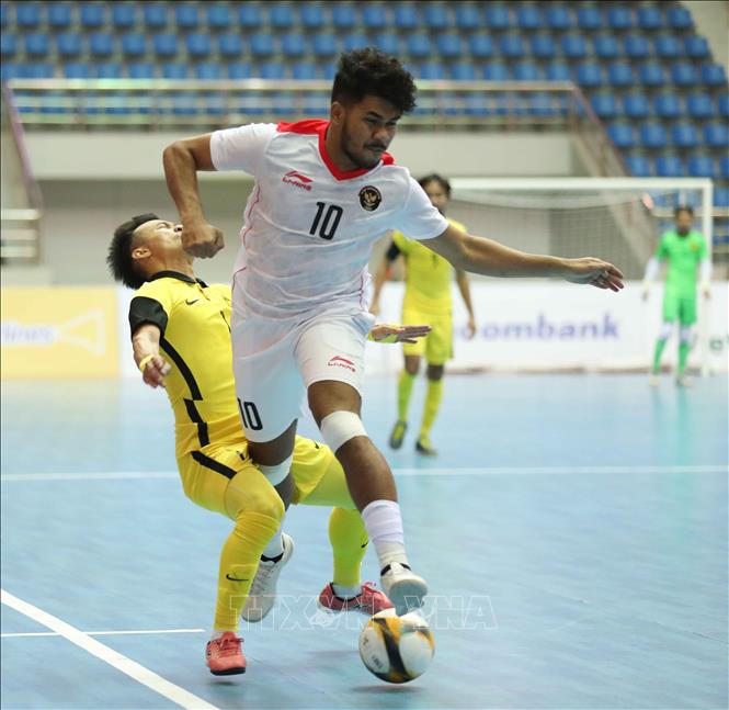 Pha bóng va chạm với Holypaul Septinus N Soumilena (10, INdonesia) khiến Mohd Khairul Effendy Bin Mohd Bahrin (7) của Malaysia bị đau. Ảnh: Thanh Tùng - TTXVN
