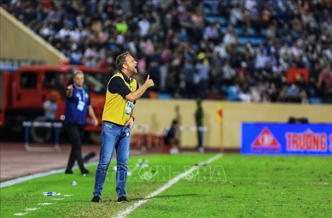 Huấn luyện viên hai đội ra tận đường biên chỉ đạo các cầu thủ. Ảnh: Tuấn Anh - TTXVN