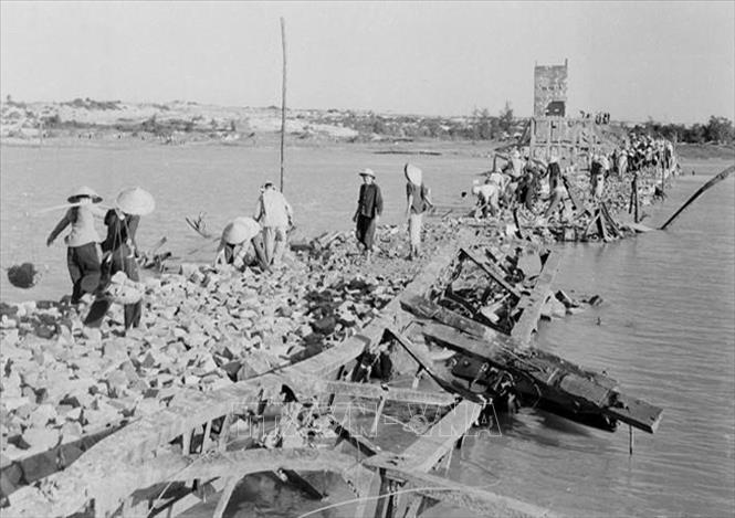 Lực lượng thanh niên xung phong và dân công hỏa tuyến khôi phục cầu phà bị địch bắn phá, nối liền mạch máu giao thông đường Trường Sơn, đoạn qua tỉnh Quảng Bình. Ảnh: Bá Luận - TTXVN