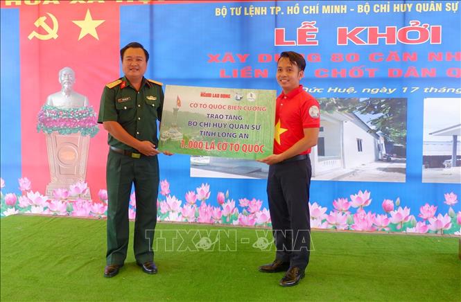 Trong ảnh: Đại diện báo Người lao động trao tặng Bộ Chỉ huy Quân sự Long An 1.000 lá cờ Tổ Quốc. Ảnh: Thanh Bình-TTXVN