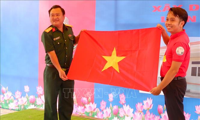 Trong ảnh: Đại diện báo Người lao động trao tặng Bộ Chỉ huy Quân sự Long An 1.000 lá cờ Tổ Quốc. Ảnh: Thanh Bình-TTXVN