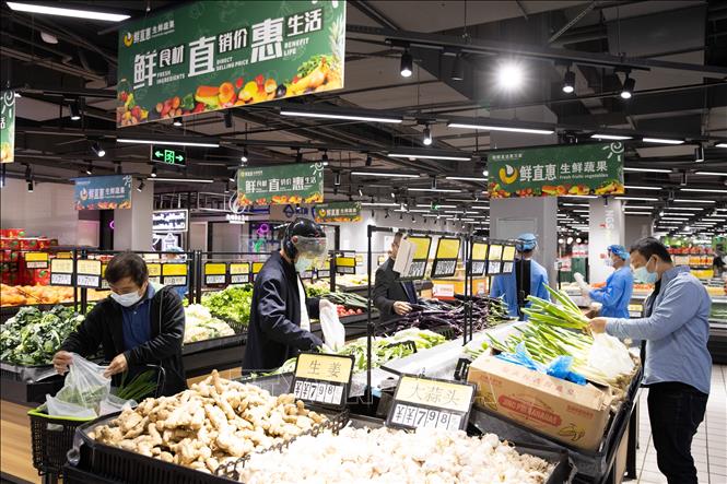 Trong ảnh: Người dân đeo khẩu trang phòng dịch COVID-19 khi đi siêu thị ở Thượng Hải, Trung Quốc, ngày 16/5/2022. Ảnh: THX/TTXVN
