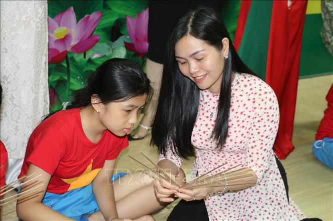 Trong ảnh: Học sinh trải nghiệm làm quạt giấy. Ảnh: Bích Huệ - TTXVN