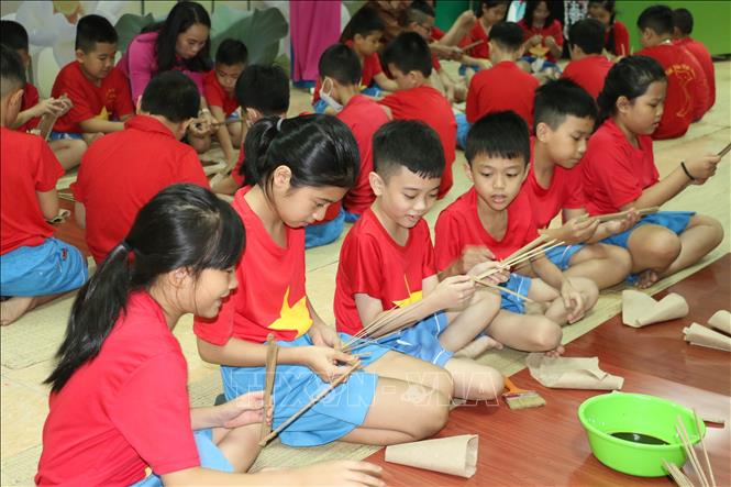 Trong ảnh: Học sinh trải nghiệm làm quạt giấy. Ảnh: Bích Huệ - TTXVN