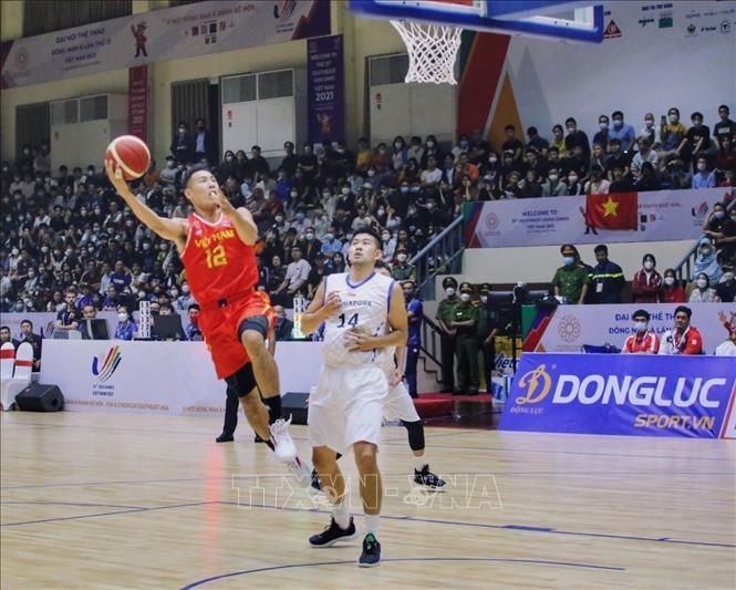 Vietnam scores into Singapore’s basket in a qualifying match of the SEA Games 31 men’s 5x5 basket ball. VNA Photo