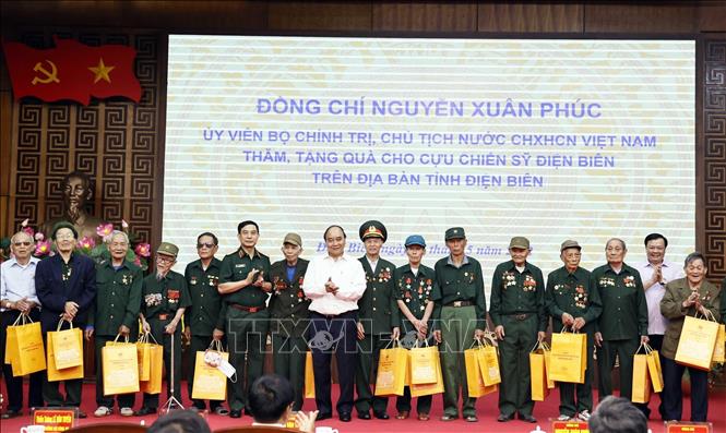 President Nguyen Xuan Phuc presents gifts to war veterans. VNA Photo: Thống Nhất 