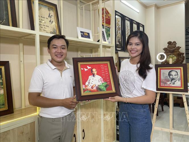 Trong ảnh: Tác giả Khưu Tấn Bửu (trái) bên tác phẩm của mình. Ảnh: Ánh Tuyết - TTXVN