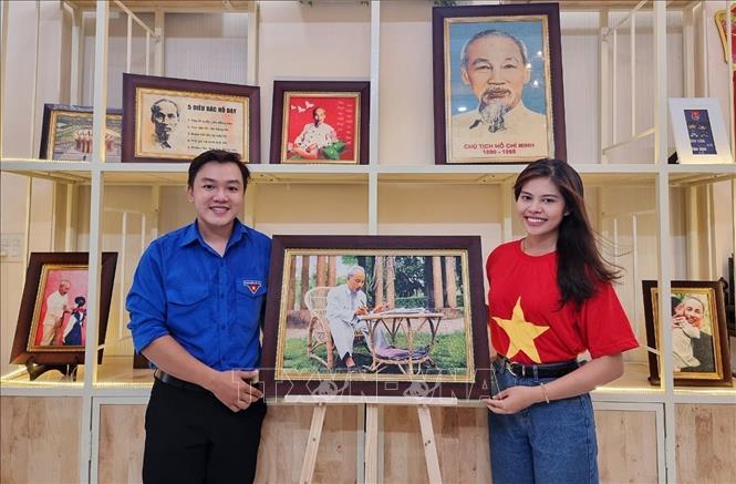 Trong ảnh: Chàng trai trẻ Khưu Tấn Bửu với tác phẩm tranh gạo Bác đang ngồi làm việc. Ảnh: Ánh Tuyết - TTXVN