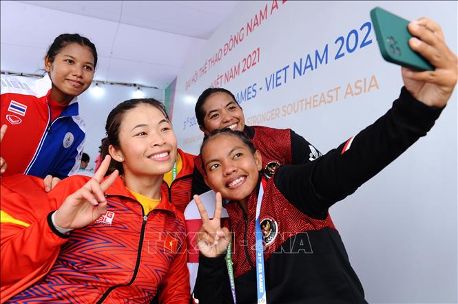 VĐV Trương Thị Phương (dân tộc Sán Dìu, đỏ) của đội tuyển Việt Nam - HCV nội dung thuyền đôi nữ Canoeing 1000m (WC2 1000), vui mừng selfie cùng VĐV đội tuyển Indonesia. Ảnh: Minh Đức – TTXVN