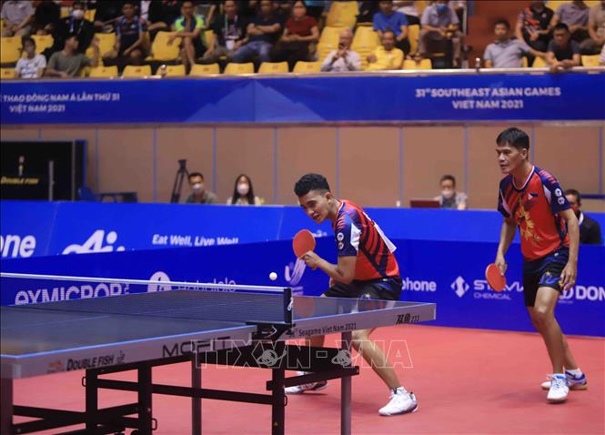 Pha phòng thủ của VĐV số 22 John Russel Misal (Philippines áo đỏ) trong trận đối đầu với VĐV số 30 Chew Zhe Yu Clarence và Poh Shao Fewg Ethan số 34 (Singapore áo xanh). Ảnh: Quý Trung – TTXVN