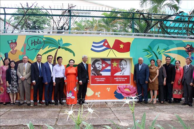 Trong ảnh: Các đại biểu chụp hình lưu niệm bên bức tranh vẽ cổ động về tình hữu nghị nhân dân Việt Nam – Cuba. Ảnh: Tiến Lực – TTXVN
