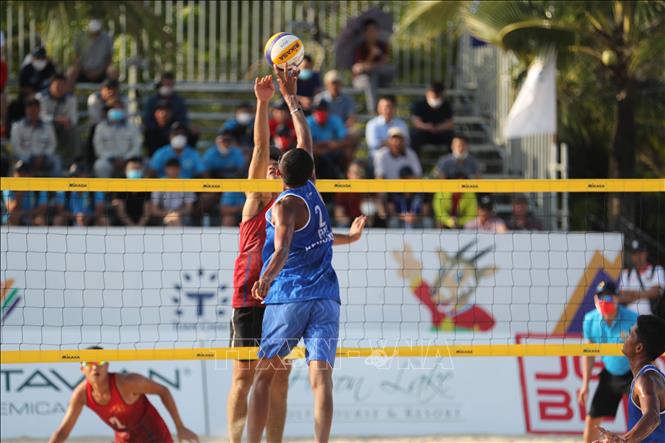 A fight for the ball during the men's beach volleyball match. VNA Photo: Công Đạt
