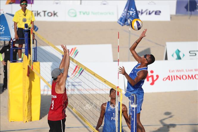 A fight for the ball during the men's beach volleyball match. VNA Photo: Công Đạt