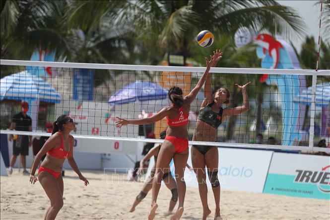 A fight for the ball during the women's beach volleyball match. VNA Photo: Công Đạt