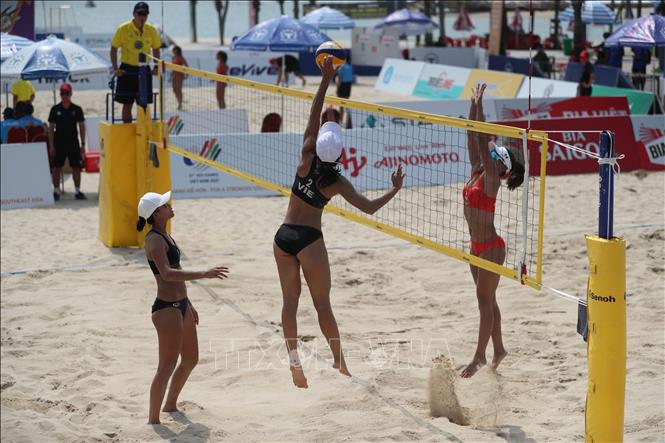 A fight for the ball during the women's beach volleyball match. VNA Photo: Công Đạt