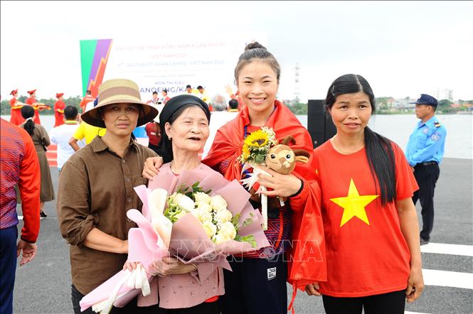 Niềm vui của VĐV Trương Thị Phương (dân tộc Sán Dìu) bên mẹ và bà khi đoạt HCV nội dung thuyền 4 nữ Canoeing 1000m (WC4 1000). Ảnh: Minh Đức – TTXVN