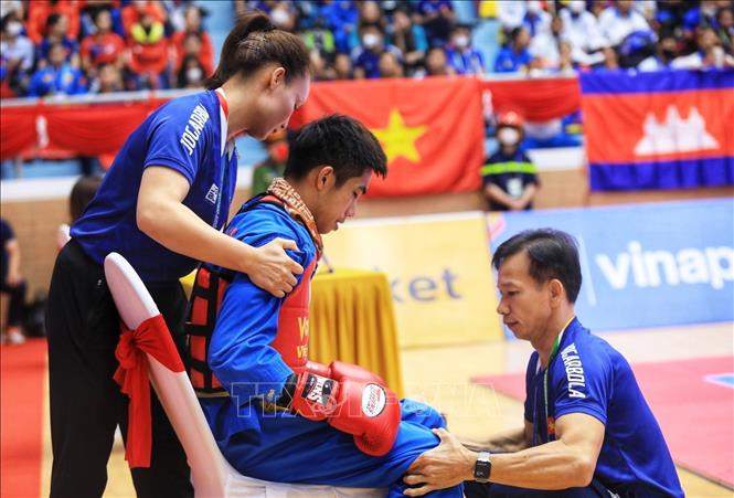 Huấn luyện viên đội tuyển Vovinam Việt Nam chăm sóc và bàn chiến thuật với VĐV Nguyễn Thanh Liêm vào giờ nghỉ ngơi. Ảnh: Tuấn Anh - TTXVN