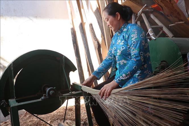 Trong ảnh: Người thợ bó chổi dùng máy chặt cán chổi cho đều và đẹp. Ảnh: Chương Đài - TTXVN