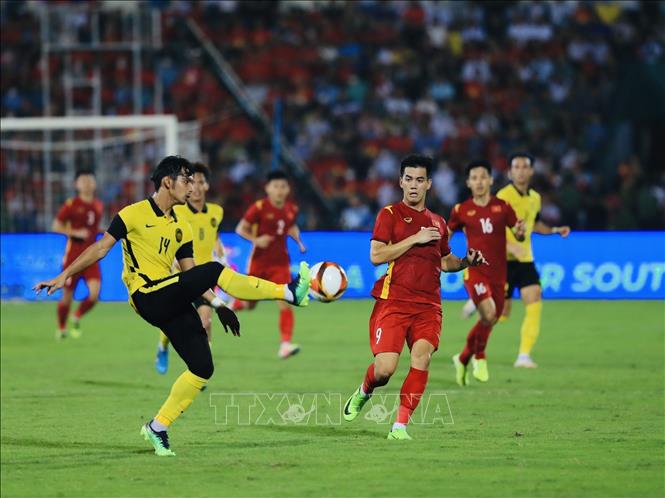 Tien Linh (9) compete for the ball with Malaysian rivals. VNA Photo