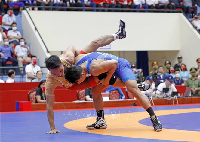 Wrestler Nguyen Xuan Dinh (blue shirt) competes against wrestler Morte from the Philippines in the men's 65 kg weight class. VNA Photo: Trần Việt 