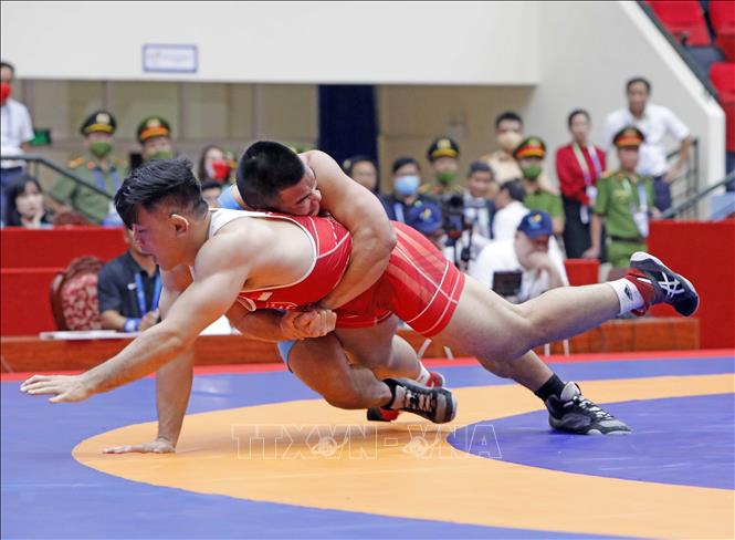 Wrestler Tran Van Truong Vu (blue shirt) competes against wrestler TGary Chow from Singapore in the men's 86 kg weight class. VNA Photo: Trần Việt 