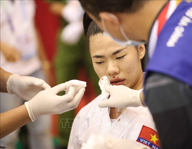 VĐV Nguyễn Thị Ngoan (đai xanh) bị chấn thương chảy máu mũi khi thi đấu trong trận chung kết nội dung Kumite đồng đội nữ với VĐV Indonesia (đai đỏ). Ảnh: Thanh Tùng-TTXVN