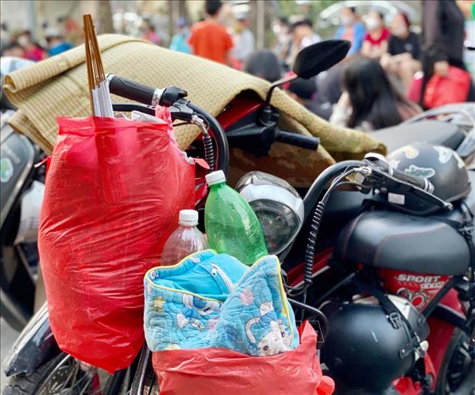 Trong ảnh: Người dân chuẩn bị sẵn đồ ăn, chiếu nằm chờ sẵn từ tối 20/5 để nhận vé mời xem trận chung kết bóng đá nữ Việt Nan gặp Thái Lan. Ảnh: Thanh Vân-TTXVN