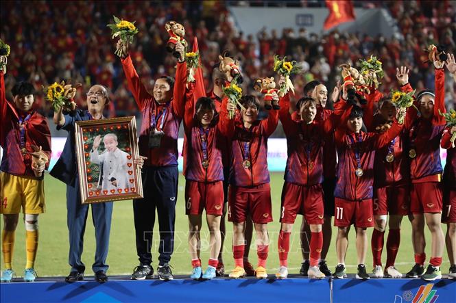 Niềm vui chiến thắng của các thành viên BHL và cầu thủ trên bục nhận HCV SEA Games 31. Ảnh: Hoàng Linh-TTXVN