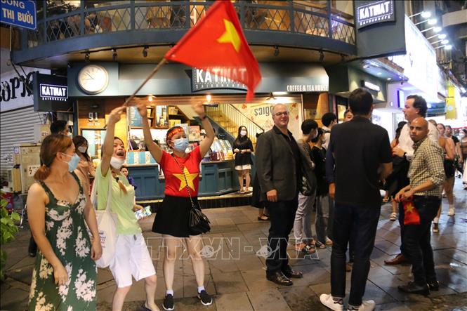 Trong ảnh: Hàng chục ngàn cổ động viên Thành phố Hồ Chí Minh dồn về các tuyến đường khu vực trung tâm Thành phố diễu hành với rực rỡ cờ đỏ sao vàng, kèn, loa… tạo nên không khí vui tươi phấn khởi. Ảnh: Thanh Vũ - TTXVN
