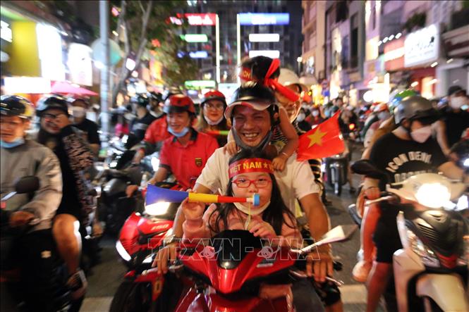 Trong ảnh: Hàng chục ngàn cổ động viên Thành phố Hồ Chí Minh dồn về các tuyến đường khu vực trung tâm Thành phố diễu hành với rực rỡ cờ đỏ sao vàng, kèn, loa… tạo nên không khí vui tươi phấn khởi. Ảnh: Thanh Vũ - TTXVN

