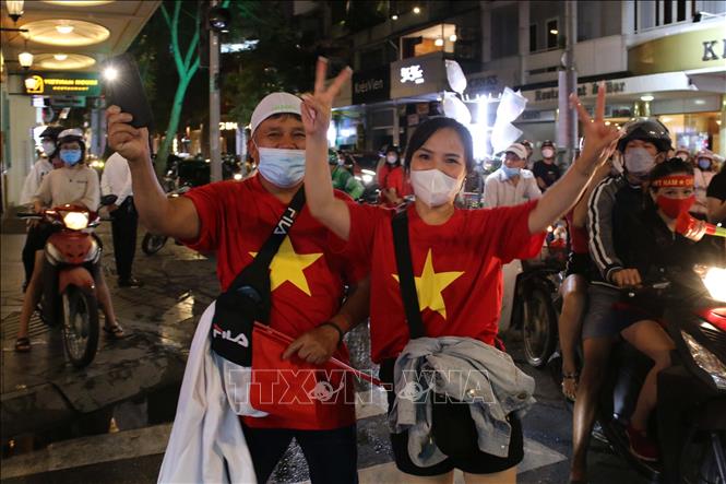 Trong ảnh: Hàng chục ngàn cổ động viên Thành phố Hồ Chí Minh dồn về các tuyến đường khu vực trung tâm Thành phố diễu hành với rực rỡ cờ đỏ sao vàng, kèn, loa… tạo nên không khí vui tươi phấn khởi. Ảnh: Thanh Vũ - TTXVN
