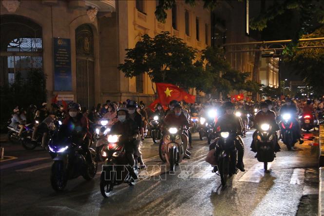 Trong ảnh: Hàng chục ngàn cổ động viên Thành phố Hồ Chí Minh dồn về các tuyến đường khu vực trung tâm Thành phố diễu hành với rực rỡ cờ đỏ sao vàng, kèn, loa… tạo nên không khí vui tươi phấn khởi. Ảnh: Thanh Vũ - TTXVN
