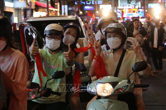 Trong ảnh: Hàng chục ngàn cổ động viên Thành phố Hồ Chí Minh dồn về các tuyến đường khu vực trung tâm Thành phố diễu hành với rực rỡ cờ đỏ sao vàng, kèn, loa… tạo nên không khí vui tươi phấn khởi. Ảnh: Thanh Vũ - TTXVN
