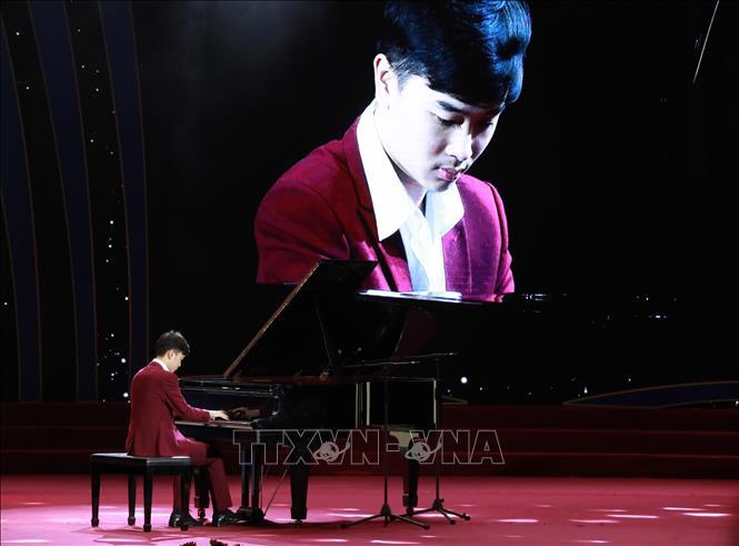 “Cậu bé vàng“ của piano Việt Nam Võ Minh Quang biểu diễn bài “Trống cơm” tại buổi lễ. Ảnh: Hoàng Hiếu - TTXVN 