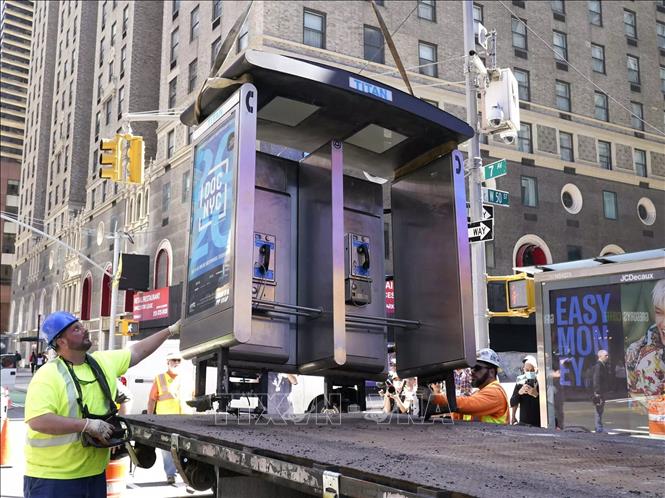 Trong ảnh: Công nhân dỡ bỏ bốt điện thoại công cộng cuối cùng ở thành phố New York (Mỹ), ngày 23/5/2022. Ảnh: AFP/TTXVN
