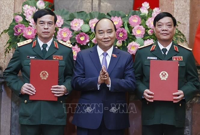 Chủ tịch nước Nguyễn Xuân Phúc, Thống lĩnh các lực lượng vũ trang nhân dân, Chủ tịch Hội đồng Quốc phòng và An ninh trao Quyết định thăng quân hàm từ Trung tướng lên Thượng tướng đối với đồng chí Ngô Minh Tiến và Lương Đình Hồng. Ảnh: Thống Nhất – TTXVN
