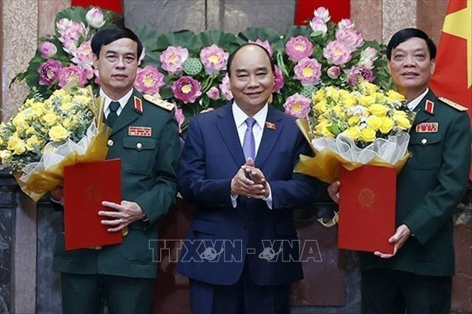 Chủ tịch nước Nguyễn Xuân Phúc, Thống lĩnh các lực lượng vũ trang nhân dân, Chủ tịch Hội đồng Quốc phòng và An ninh trao Quyết định thăng quân hàm từ Trung tướng lên Thượng tướng đối với đồng chí Ngô Minh Tiến và Lương Đình Hồng. Ảnh: Thống Nhất – TTXVN