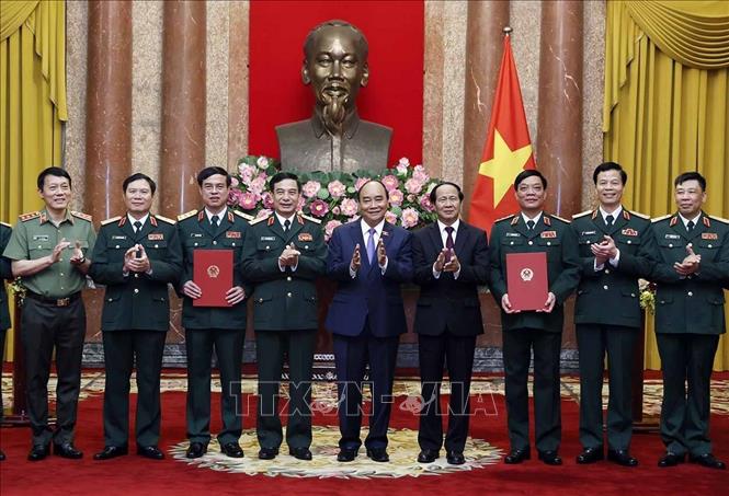 Chủ tịch nước Nguyễn Xuân Phúc, Thống lĩnh các lực lượng vũ trang nhân dân, Chủ tịch Hội đồng Quốc phòng, Phó Thủ tướng Lê Văn Thành và các đồng chí lãnh đạo Bộ Quốc phòng chúc mừng Thượng tướng Ngô Minh Tiến và Lương Đình Hồng. Ảnh: Thống Nhất – TTXVN