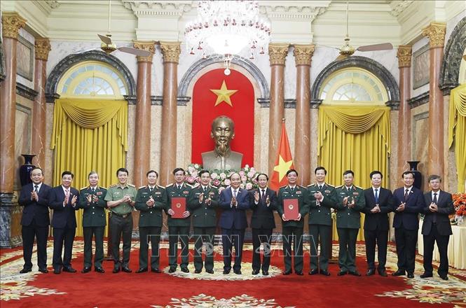 Chủ tịch nước Nguyễn Xuân Phúc, Thống lĩnh các lực lượng vũ trang nhân dân, Chủ tịch Hội đồng Quốc phòng và lãnh đạo các Bộ, ban ngành chúc mừng đồng chí Ngô Minh Tiến và Lương Đình Hồng. Ảnh: Thống Nhất – TTXVN