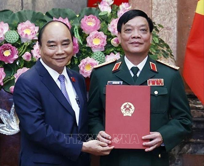 Chủ tịch nước Nguyễn Xuân Phúc, Thống lĩnh các lực lượng vũ trang nhân dân, Chủ tịch Hội đồng Quốc phòng và An ninh trao Quyết định thăng quân hàm từ Trung tướng lên Thượng tướng đối với đồng chí Ngô Minh Tiến, Phó Tổng tham mưu trưởng Quân đội nhân dân Việt Nam. Ảnh: Thống Nhất – TTXVN
