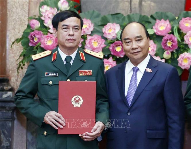 Chủ tịch nước Nguyễn Xuân Phúc, Thống lĩnh các lực lượng vũ trang nhân dân, Chủ tịch Hội đồng Quốc phòng và An ninh trao Quyết định thăng quân hàm từ Trung tướng lên Thượng tướng đối với đồng chí Lương Đình Hồng, Chính uỷ Học viện Quốc phòng. Ảnh: Thống Nhất – TTXVN
