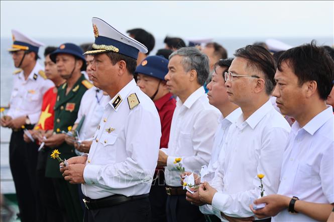 Các đại biểu kiều bào tham dự Lễ tưởng niệm cán bộ, chiến sỹ hy sinh tại quần đảo Trường Sa vì sự nghiệp bảo vệ chủ quyền biển, đảo Tổ quốc trong không khí nghiêm trang và xúc động tại boong tàu Trường Sa 571. Ảnh: Diệp Trương – TTXVN