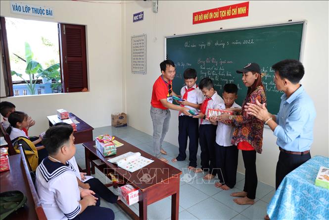 Các kiều bào tặng quà cho học sinh trường Tiểu học xã Song Tử Tây, huyện đảo Trường Sa, tỉnh Khánh Hòa. Ảnh: Diệp Trương – TTXVN