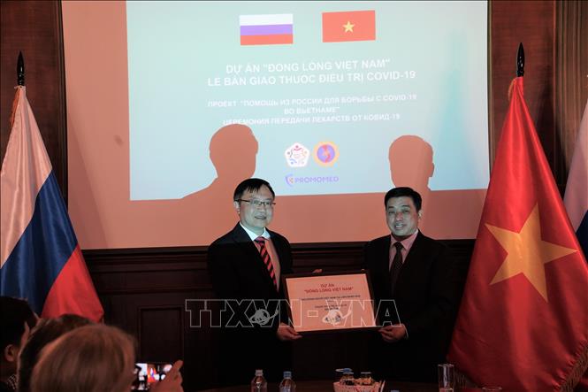 Thay mặt Đại sứ quán Việt Nam tại LB Nga, Tham tán Công sứ Lê Quang Anh (trái) nhận tượng trưng việc chuyển giao lô thuốc từ Phó Chủ tịch thường trực Hội người Việt Nam tại LB Nga Trần Phú Thuận. Ảnh: Duy Trinh - P/v TTXVN tại Liên bang Nga

