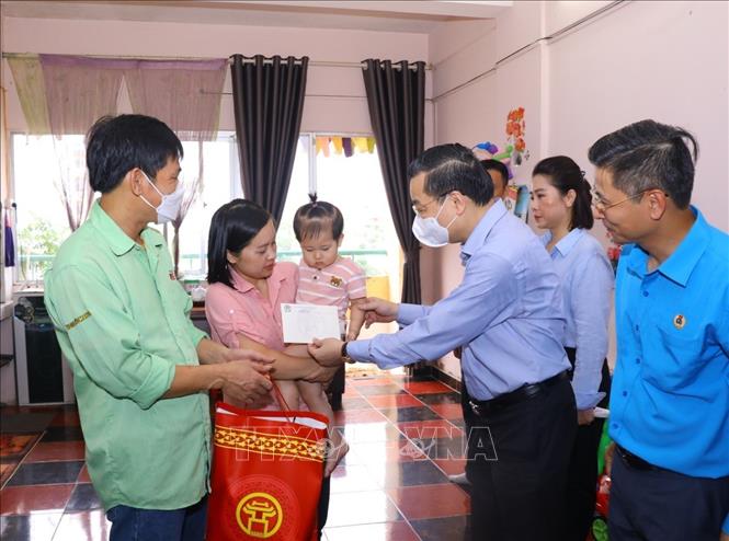 Chủ tịch UBND thành phố Hà Nội Chu Ngọc Anh thăm, tặng quà đình anh Nguyễn Đình Tư, công nhân Công ty TNHH ToTo Việt Nam, KCN Thăng Long. Ảnh: Văn Điệp - TTXVN