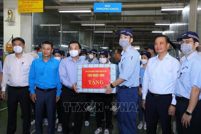 Chủ tịch UBND Thành phố Hà Nội Chu Ngọc Anh tặng quà cho công nhân Công ty TNHH Nisei tại KCN Thăng Long, huyện Đông Anh. Ảnh: Văn Điệp - TTXVN