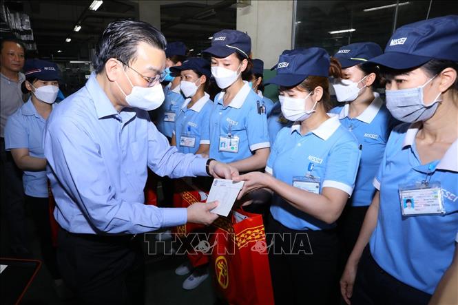 Chủ tịch UBND thành phố Hà Nội Chu Ngọc Anh tặng quà cho người lao động của Công ty TNHH Nisei tại KCN Thăng Long, huyện Đông Anh. Ảnh: Văn Điệp - TTXVN